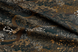 Close-up of dark fabric with bronze and white floral illustrations, styled for mobile to highlight texture, pattern, and vintage-inspired detail.