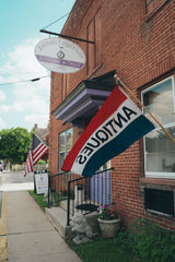 Brick building with Zelma's Emporium sign and American flag, featuring a Zelma's Emporium flag.
