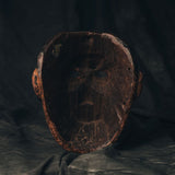 Antique 18th Century Guatemalan wood mask on a textured dark background