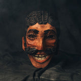 Wooden mask with intricate carvings on a dark background
