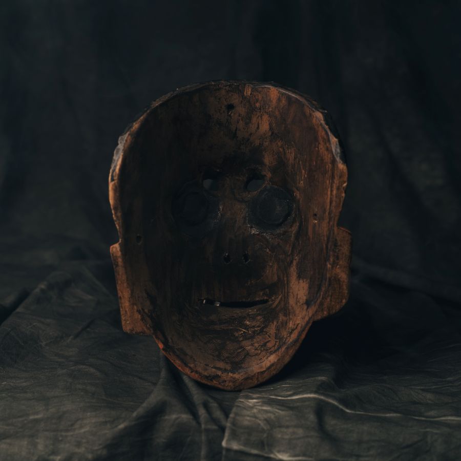 Wooden mask on a dark fabric background