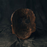 Wooden mask on a dark fabric background