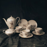 A Bavarian tea set with teapot, cups, and saucers on a dark surface