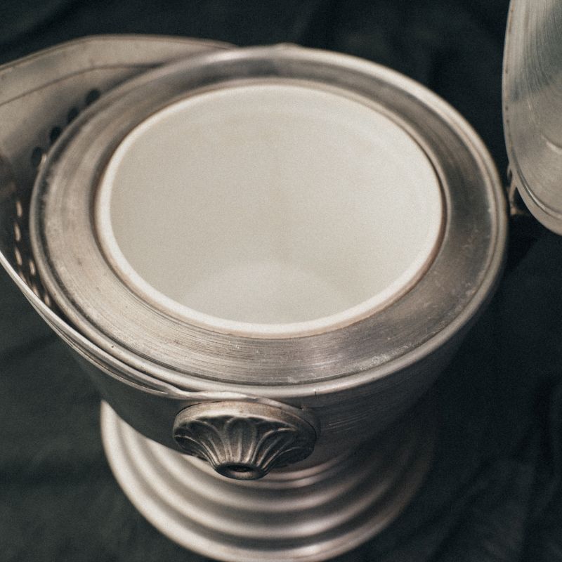 Interior view of the knight’s helmet ice bucket showing the brushed aluminum basin and functional depth.