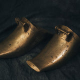 Close-up of the brass stirrups’ curved edge and timeworn finish, capturing the weight and character of the vintage metal.