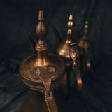 Close-up of the handle on a vintage Turkish coffee pot, showing the riveted brasswork and curved grip shaped by hand.