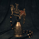 Full view of the early 20th century Gothic brass monastery bell from The Night’s Tale collection, styled in shadowy light to highlight its aged patina and architectural detail.