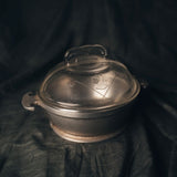 Vintage silver pot with a lid on a dark fabric background