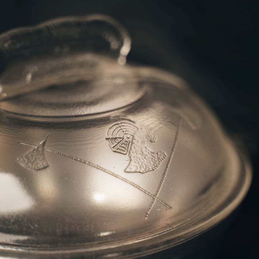 Close-up of One Quart Dome Cooker with engraved designs on a dark background