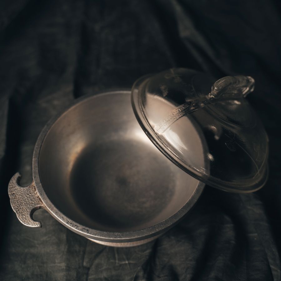 Decorative aluminum dome cooker with a lid on a dark background