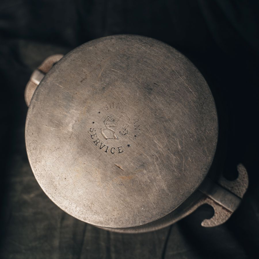 Close-up of a Guardian Service One Quart Dome Cooker with 'Guardian Service' engraved on the bottom