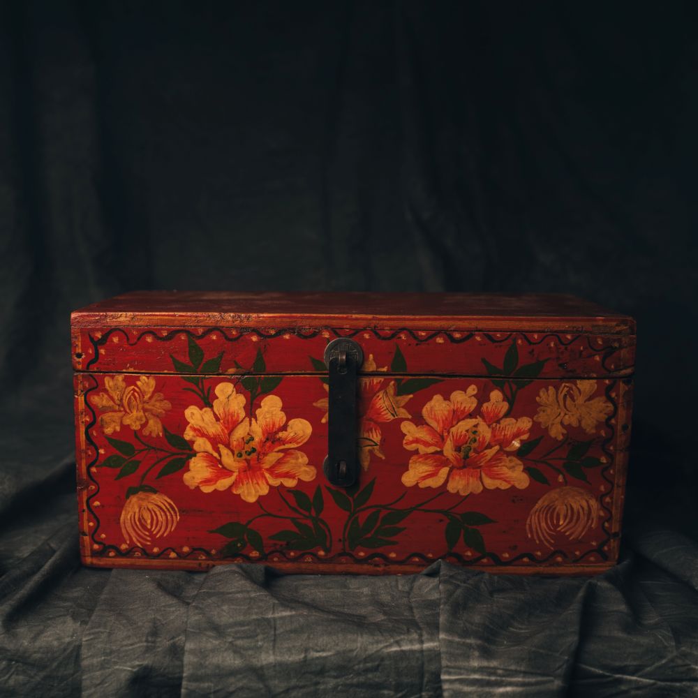 Decorative wooden box with floral patterns on a dark background