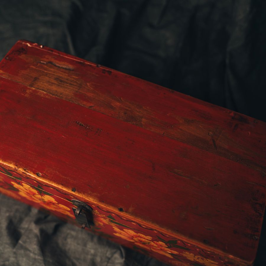 Vintage red hand painted wooden box with a dark background