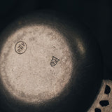 Close-up photo of the bottom of the pewter bowl with branding and design details.