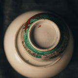Close-up of a ceramic vase with decorative elements on a dark background