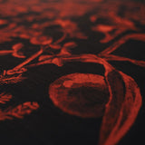 Close-up of the cotton linen seasons greetings mulberry fabric with a red floral design