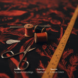 Spools of thread and a ruler on the Seasons Greetings mulberry cotton linen fabric with 'Season's Greetings' text overlay.