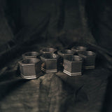 Eight Hexagonal Wilton Columbia Pewter Napkin Rings arranged on a black fabric background