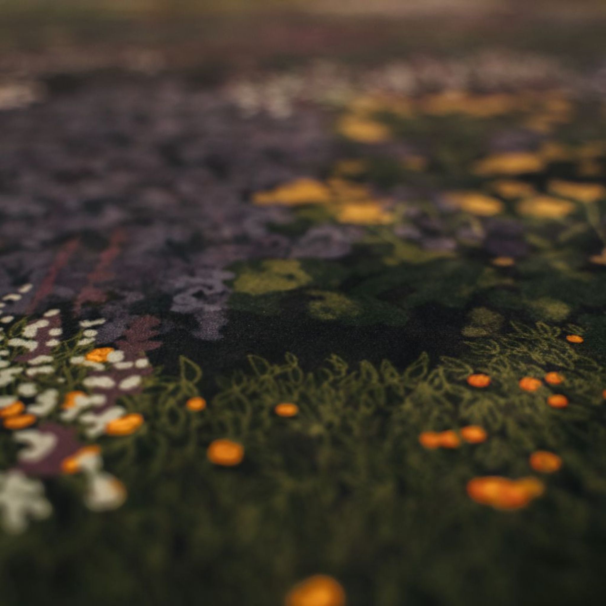 Close-up of the textured The Night's Tale Amethyst fabric with floral patterns in various colors.