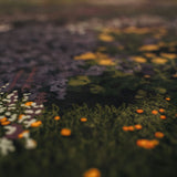 Close-up of the textured The Night's Tale Amethyst fabric with floral patterns in various colors.