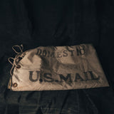 Vintage U.S. Mail bag with 'DOMESTIC U.S. MAIL' text on a dark background