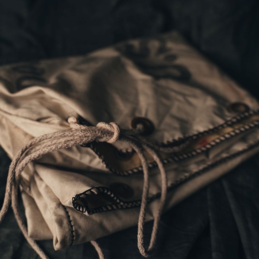 Close-up of a folded fabric item with a drawstring on a dark background
